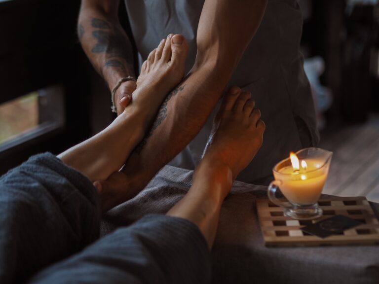 Réflexologie A serene foot massage session lit by candlelight, ideal for relaxation and spa treatments.