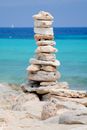 A serene stone tower against a backdrop of turquoise waters and blue skies.
